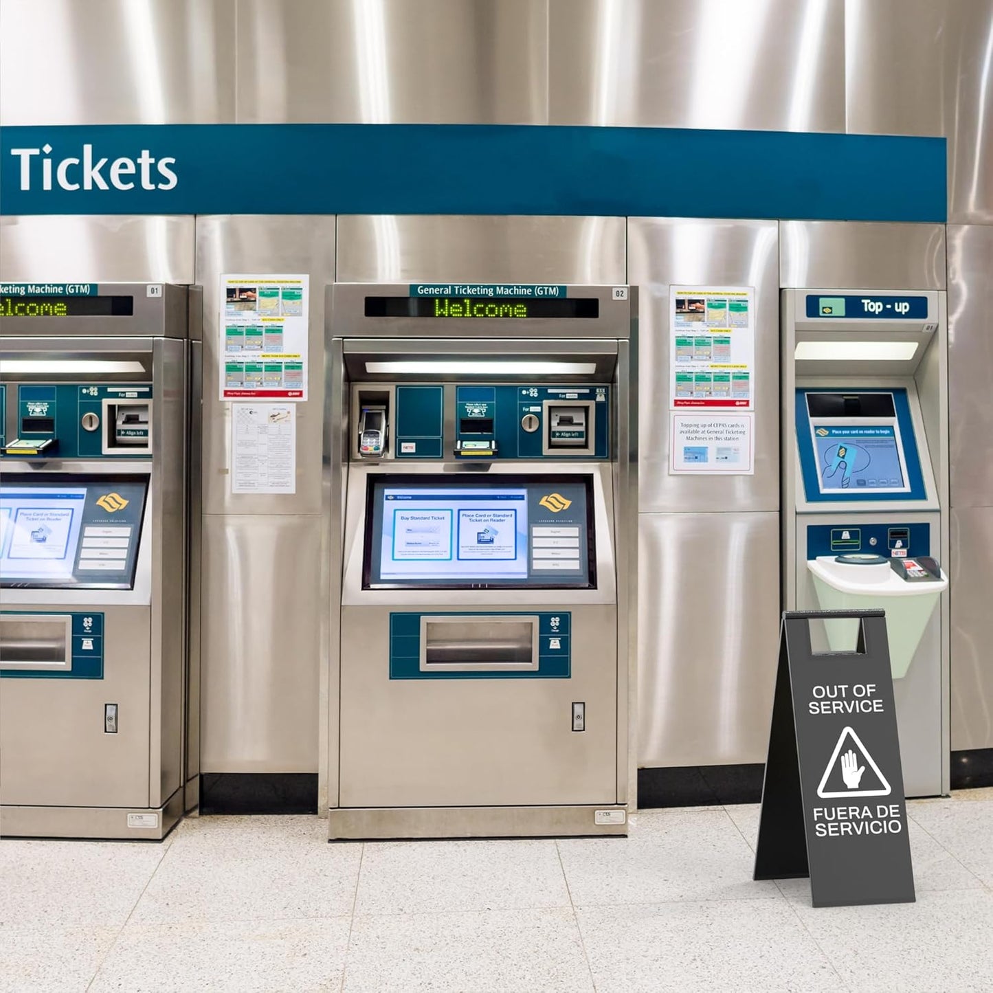Black equipment out of service sign with hand stop symbol positioned next to subway ticket machines during maintenance