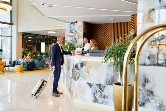 A businessman checking in at a modern hotel reception desk with marble counters and contemporary lobby design.