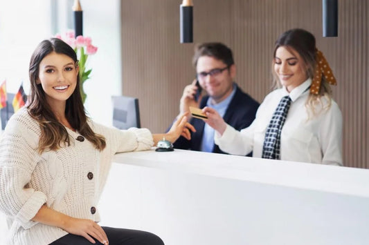 Hotel reception desk service staff assisting guest check-in at modern hospitality front desk