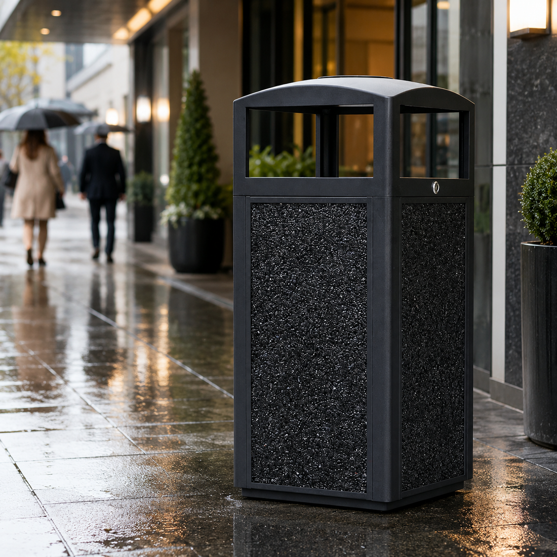 Outdoor metal trash can placed at a rainy hotel entrance, showing a clean and professional waste solution