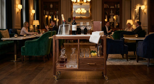 Wooden beverage service cart in a luxury hotel lounge with wine, glassware, and premium drink service setup