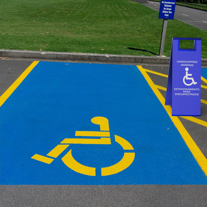 Blue accessible parking sign positioned next to painted wheelchair symbol on parking lot pavement