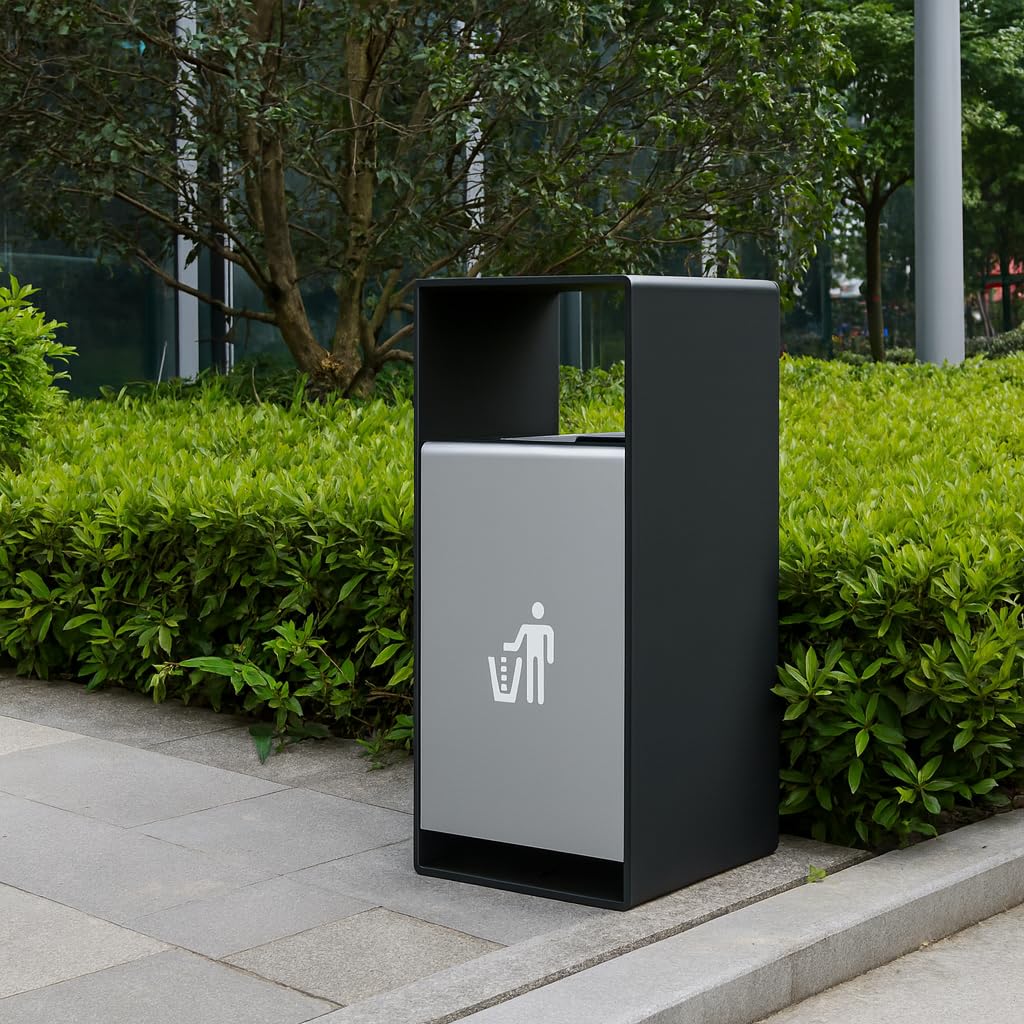 Modern outdoor waste bin with gray and black finish installed in landscaped park area with green shrubs