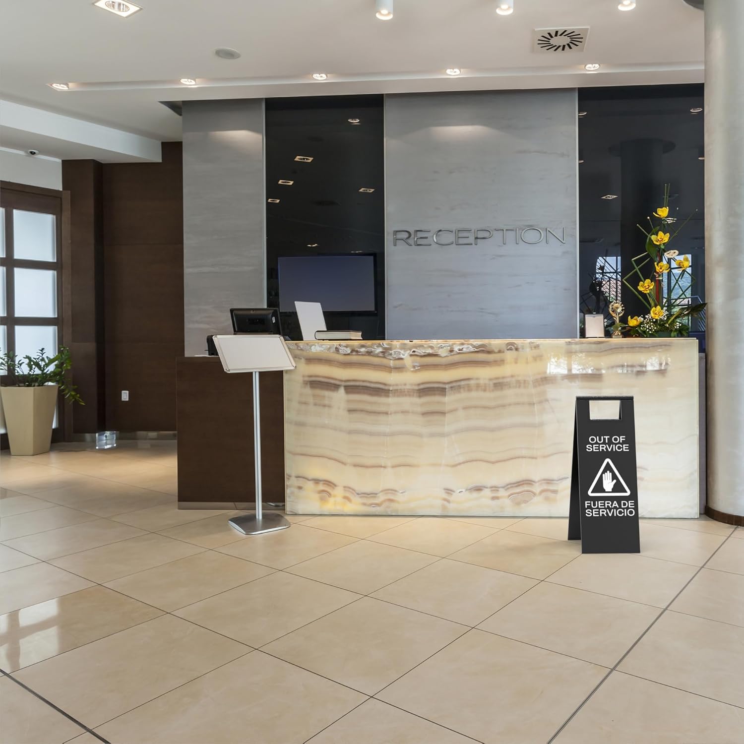 Black service unavailable sign with warning triangle placed at modern hotel reception desk during maintenance
