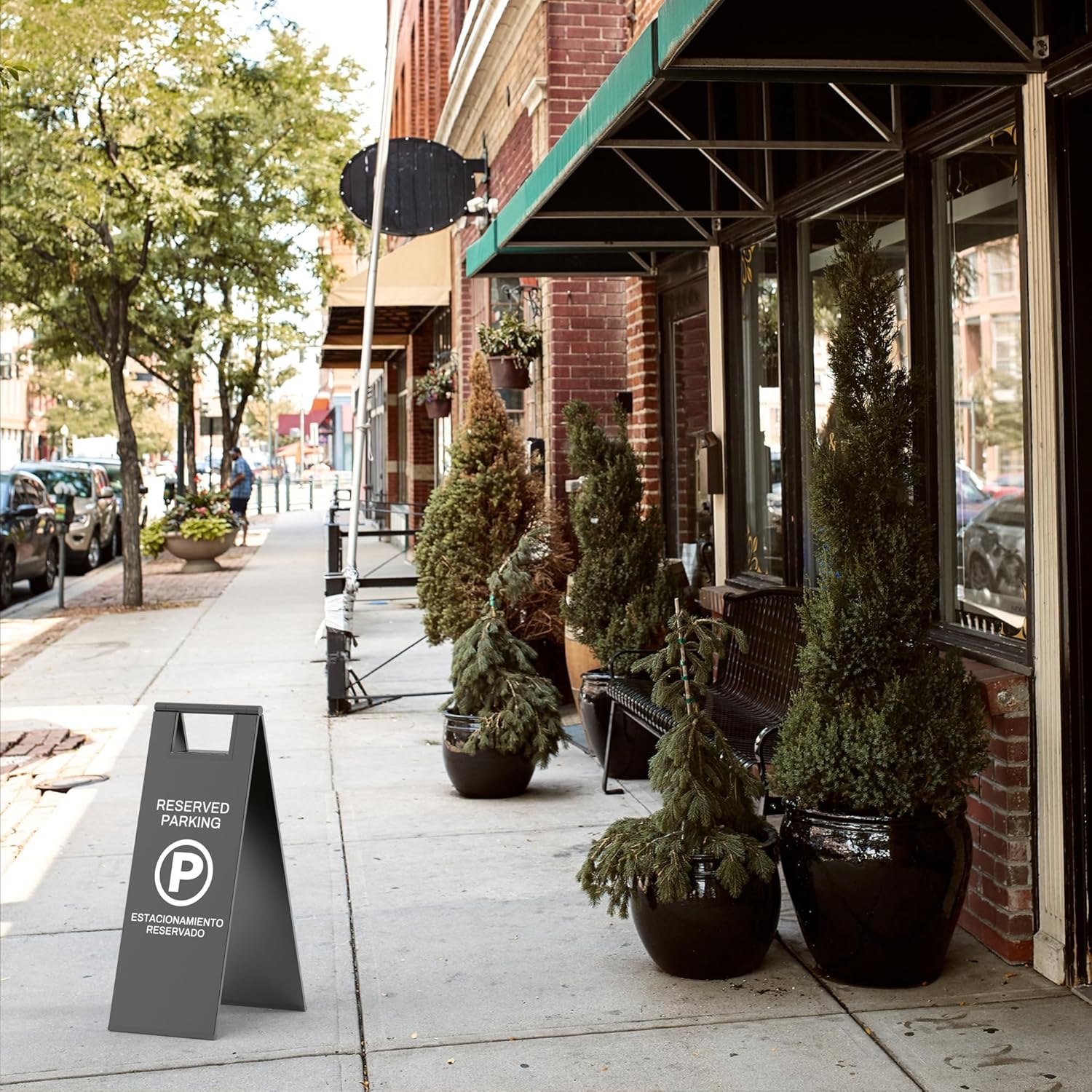 Black reserved parking floor sign a-frame stand placed on sidewalk outside retail store for designated parking space management