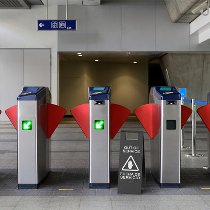 Black temporary out of service sign with hand symbol blocking access to subway turnstile gates during repair