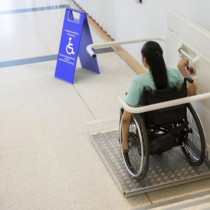 Blue wheelchair parking sign positioned near accessibility ramp with person in wheelchair demonstrating usage