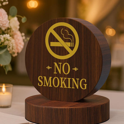 Circular wooden no smoking sign with golden prohibition symbol on wooden base, restaurant table setting