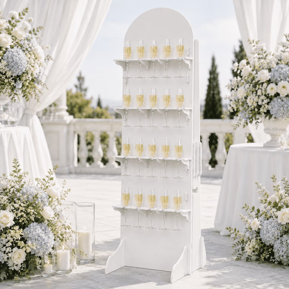 Freestanding white 20-flute PVC champagne wall surrounded by white wedding flowers and drapery